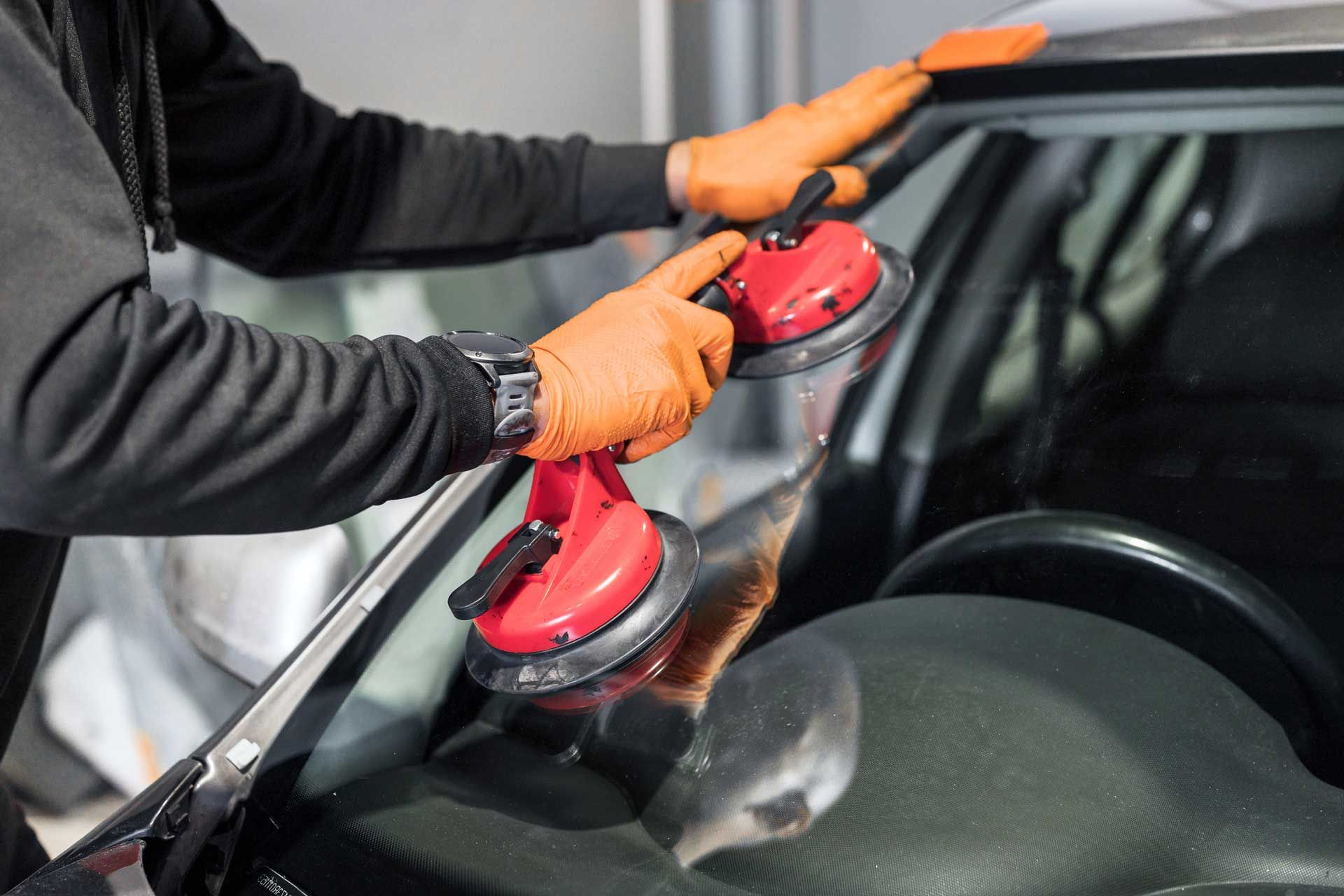 A man is installing a windshield on a car.