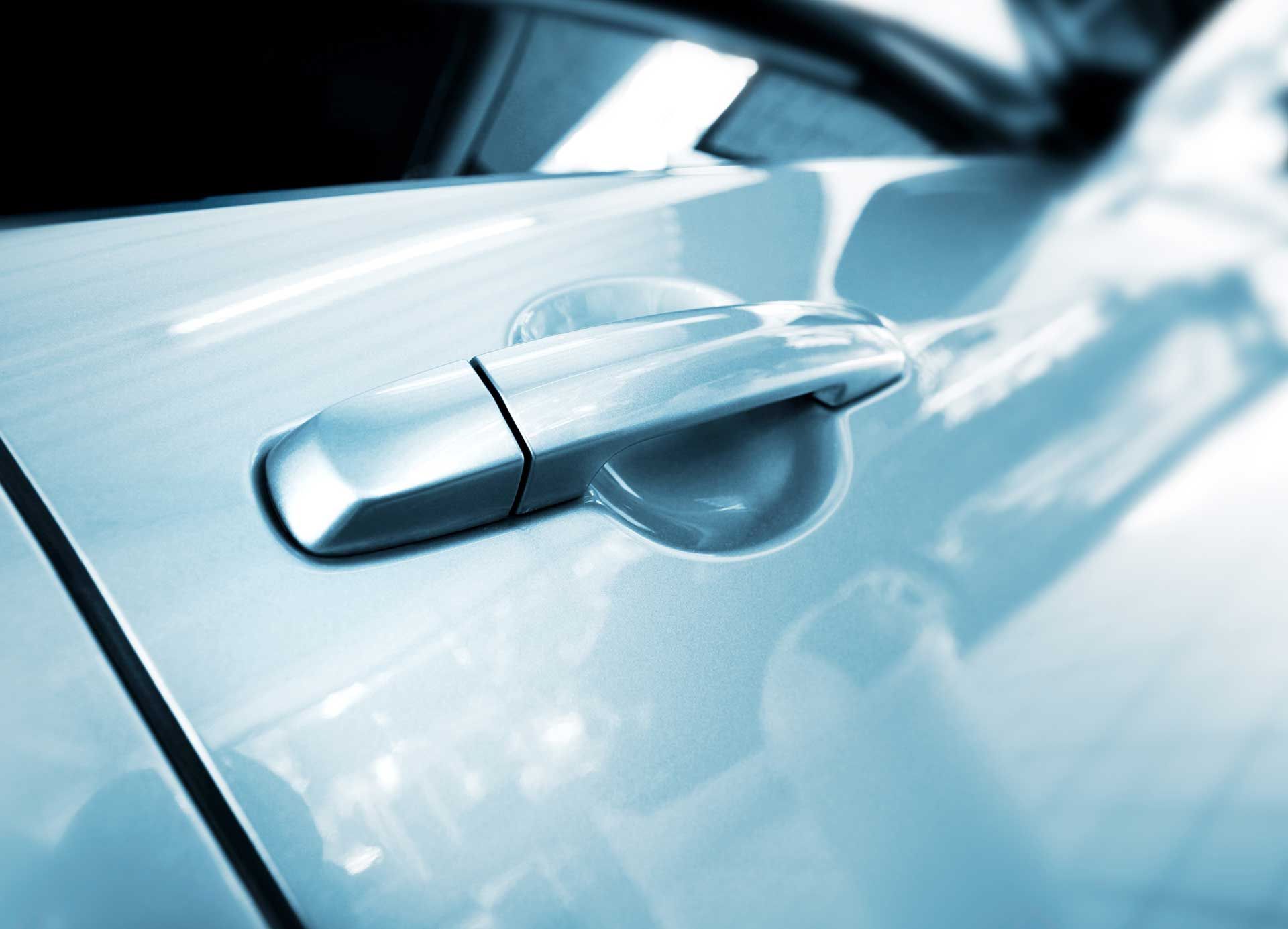 A close up of a car door handle on a blue car