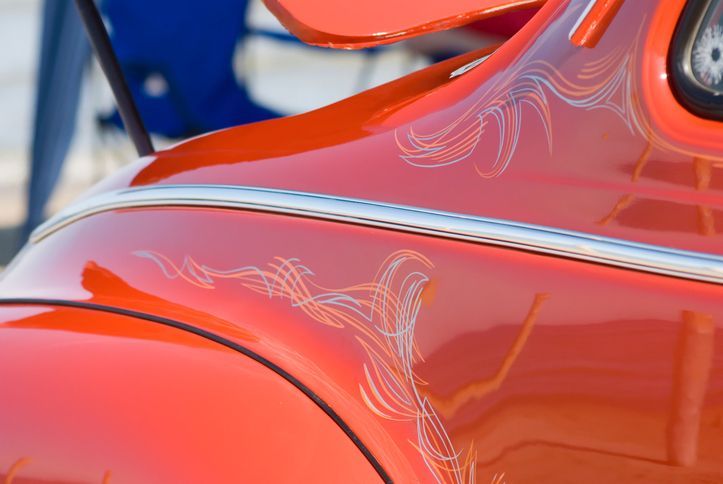 A close up of a red car with a swirl painted on it