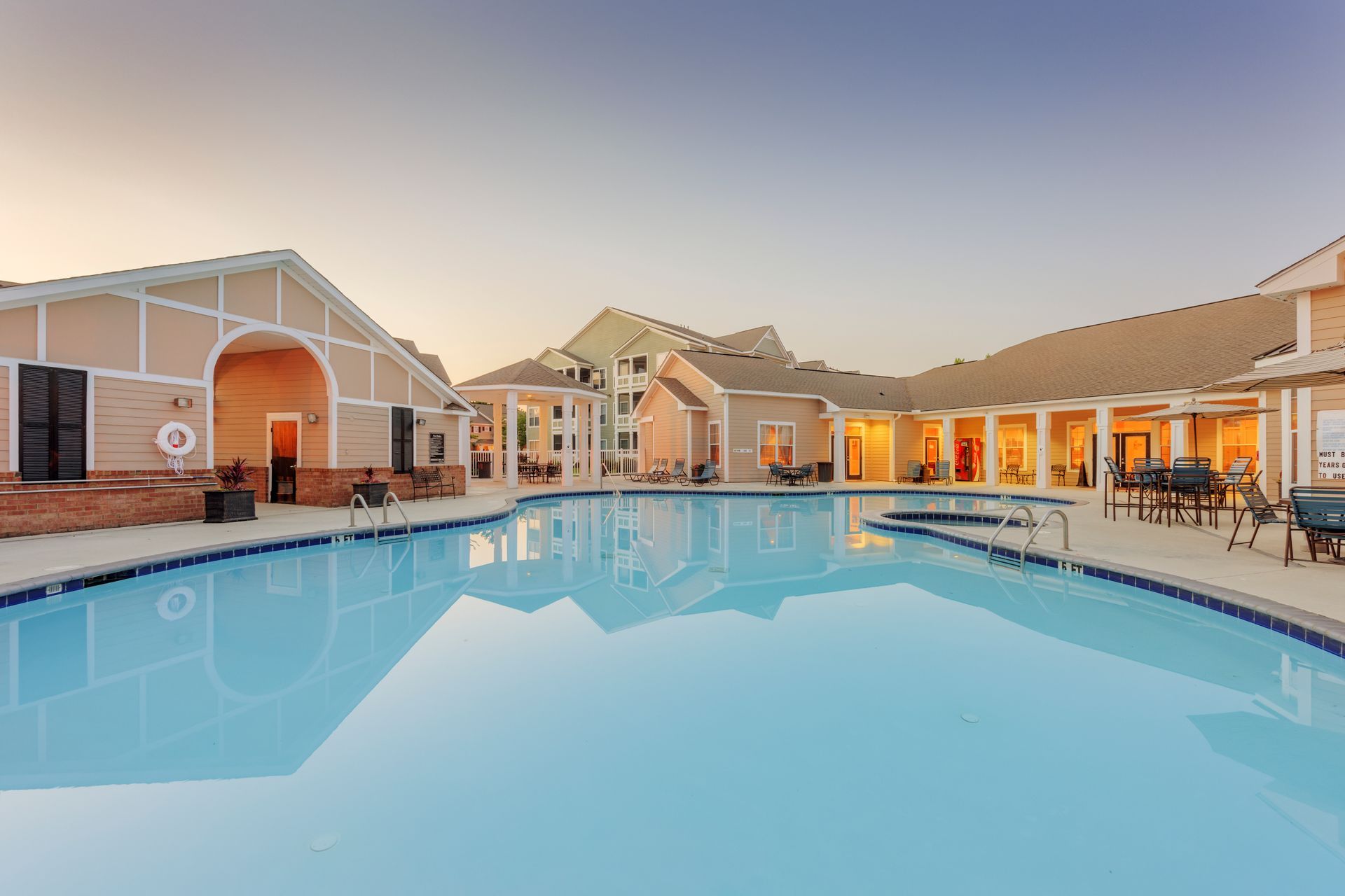 Swimming pool in front of apartment buildings at sunset.