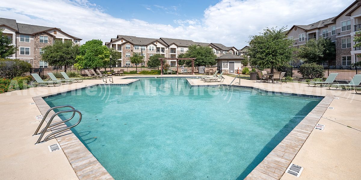 Swimming pool in front of apartment buildings on a sunny day.