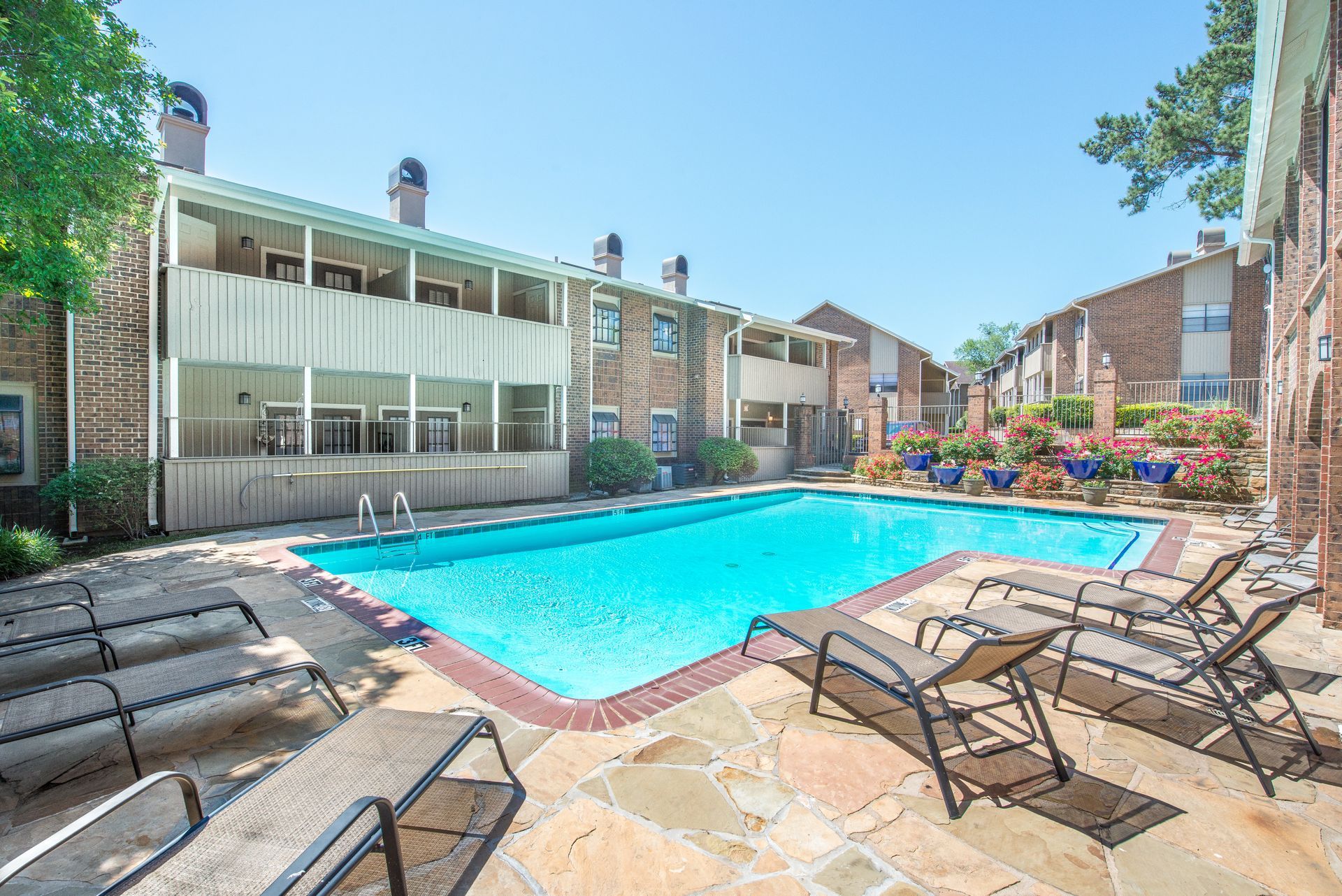 A group of people are sitting at a table looking at a tablet.