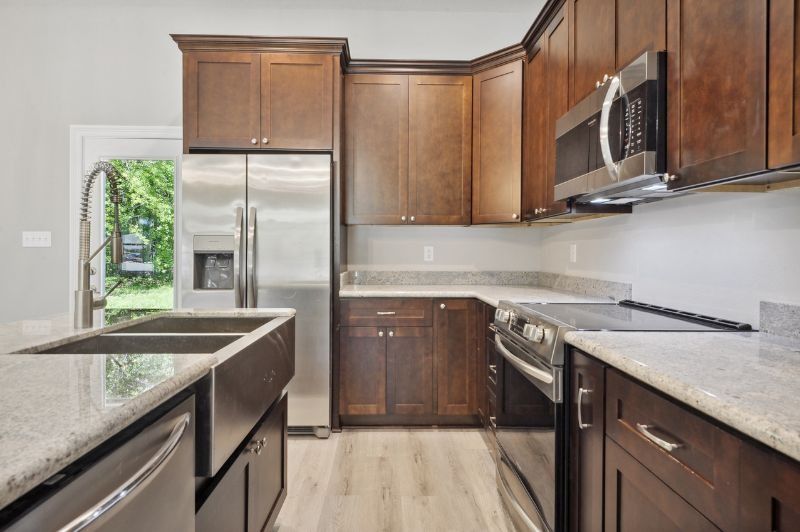 Kitchen with dark wood cabinets, stainless steel appliances, and light countertops.