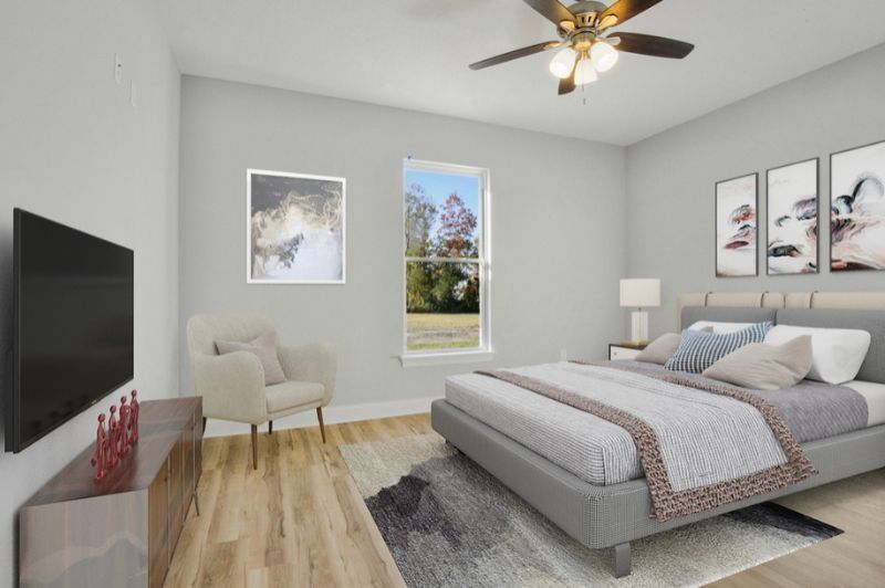 Bedroom with bed, TV, armchair, artwork, and window; gray walls, light wood floor.