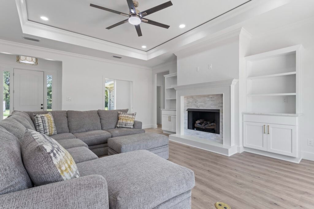 Spacious living room with a gray sectional sofa, fireplace, and built-in shelves.