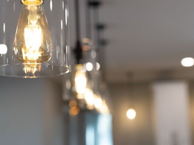 Row of hanging light fixtures with exposed light bulbs, emitting a warm glow.