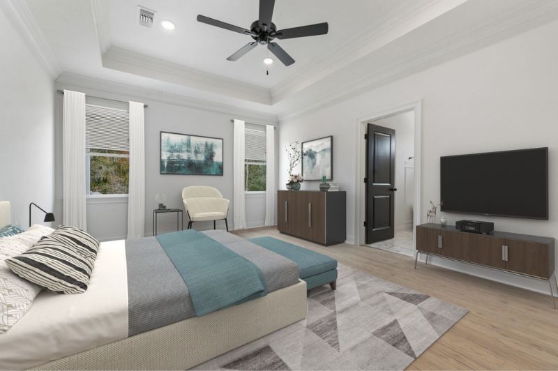 Spacious bedroom with a bed, TV, and dresser. Soft blue and gray color scheme.