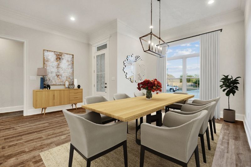Dining room with a wood table and chairs, a sideboard, art, and a large window.