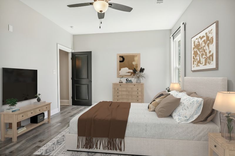 Bedroom with bed, dresser, TV, and dark door. Light walls, wood-look floor, and soft furnishings in neutral tones.