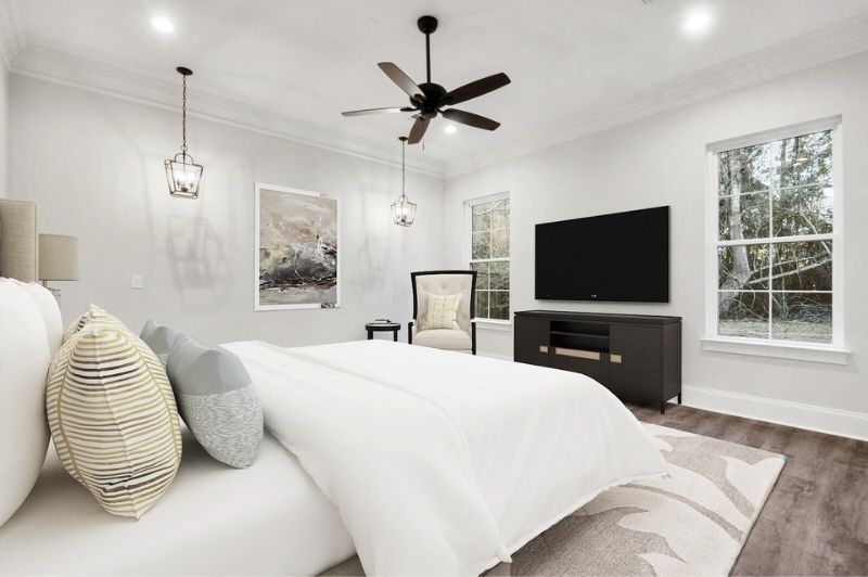 Bedroom with a large bed, TV, and windows. Neutral colors, modern style.