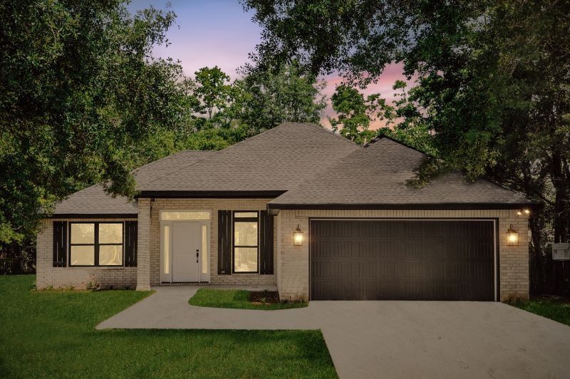 Single-story brick home with a gray roof, black garage door, and front yard with green grass and trees.