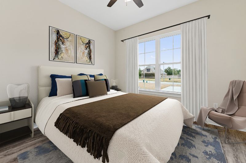 Bedroom with bed, window, art, and chair; neutral colors, natural light.