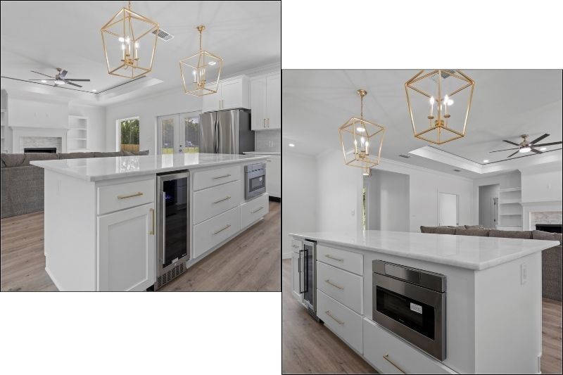 Modern kitchen with white cabinets, island with appliances, gold light fixtures.