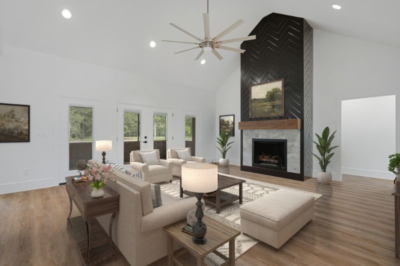 Spacious living room with fireplace, light furniture, and vaulted ceilings.