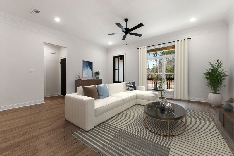 White living room with sectional sofa, rug, coffee table, and a window.