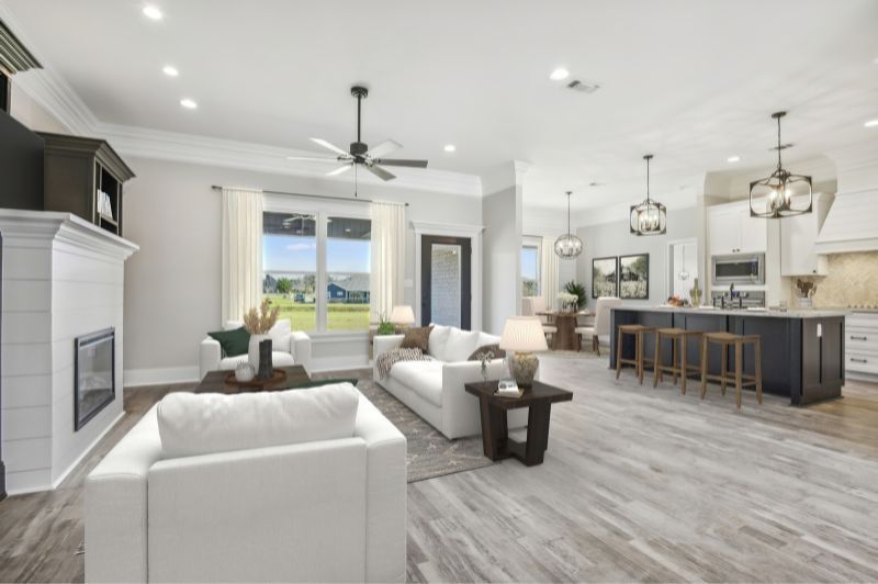 Spacious, modern living area with white furniture, dark accent island, and wooden floors.