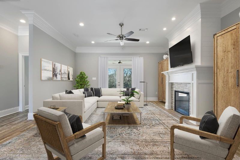 Living room with white sectional, fireplace, and French doors.