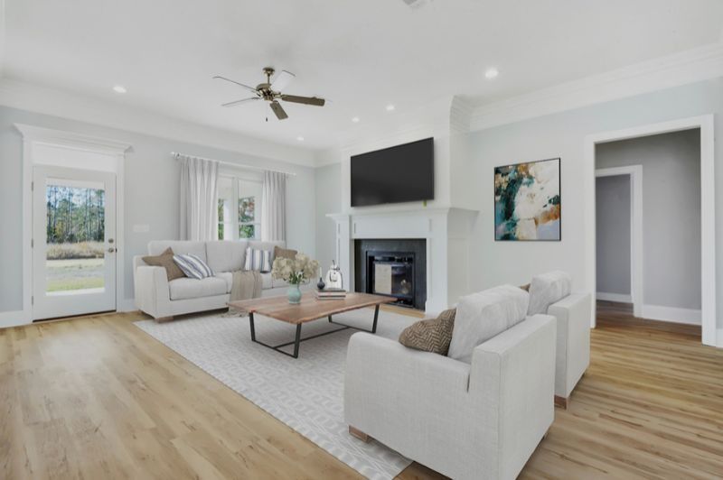 Spacious living room with light blue walls, fireplace, white furniture, and a wooden coffee table.