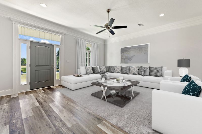 Spacious living room with white sectional sofa, gray accents, and a wooden floor.