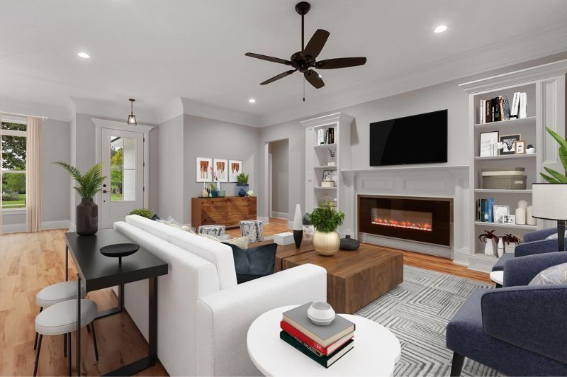 Living room with white sofa, fireplace, TV, bookshelves, and wooden coffee table.