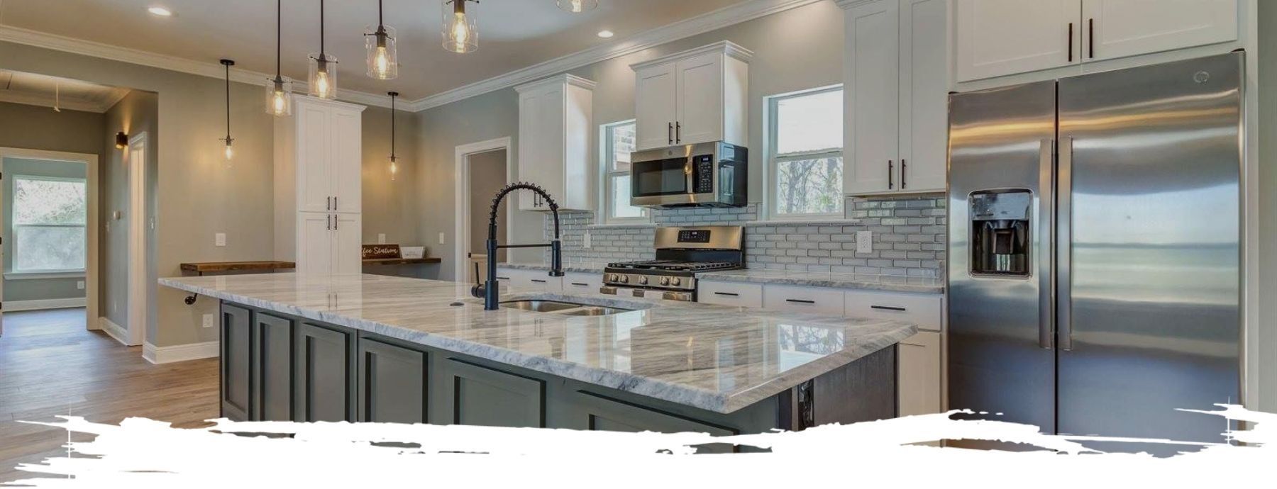 Modern kitchen with granite countertops, stainless steel appliances, and pendant lights.