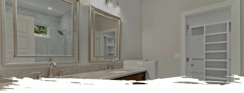 Bathroom with double mirrors, a vanity, and a closet with shelves.
