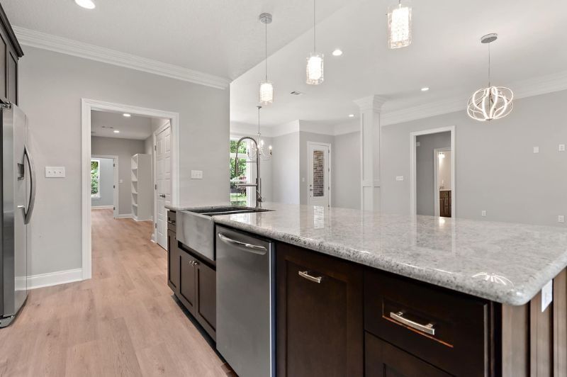 Modern kitchen with dark cabinets, stainless steel appliances, and light countertops.