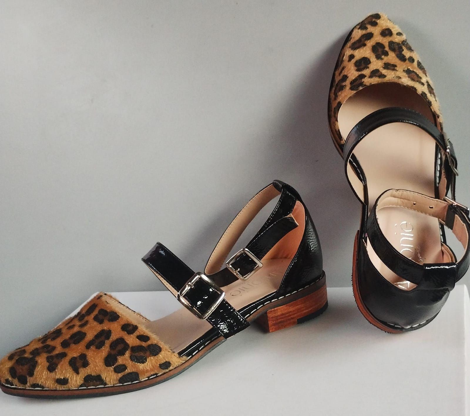 Un par de zapatos con estampado de leopardo y correas negras.