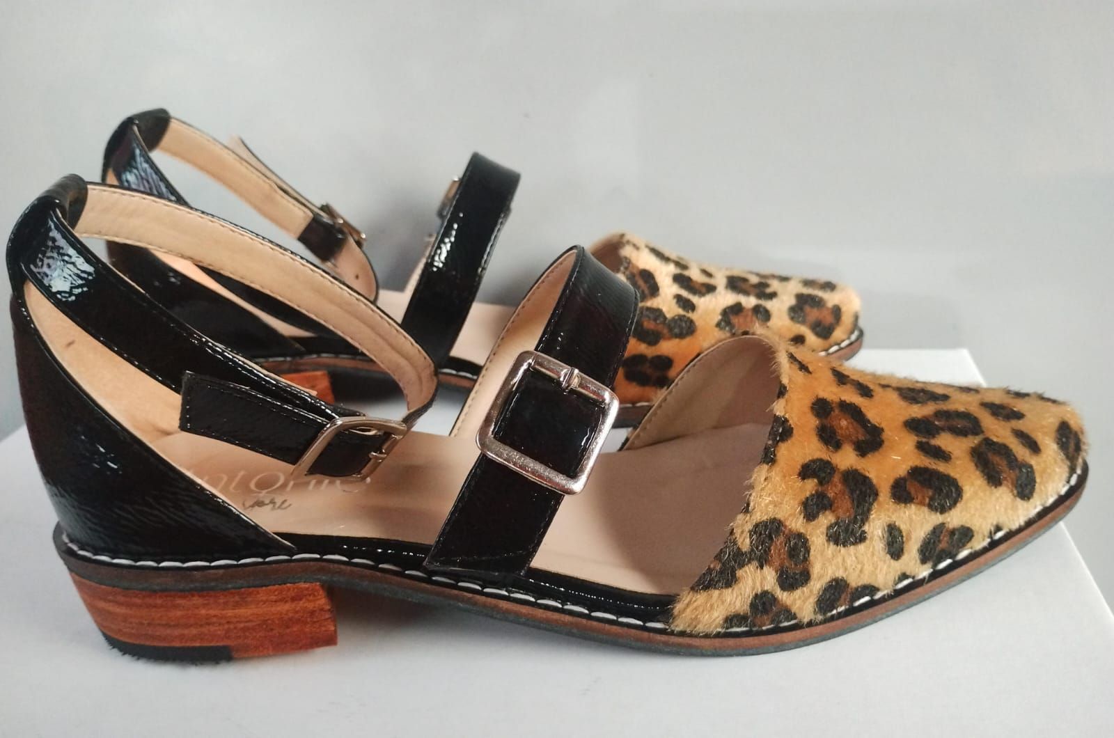 Un par de zapatos con estampado de leopardo y correas negras.