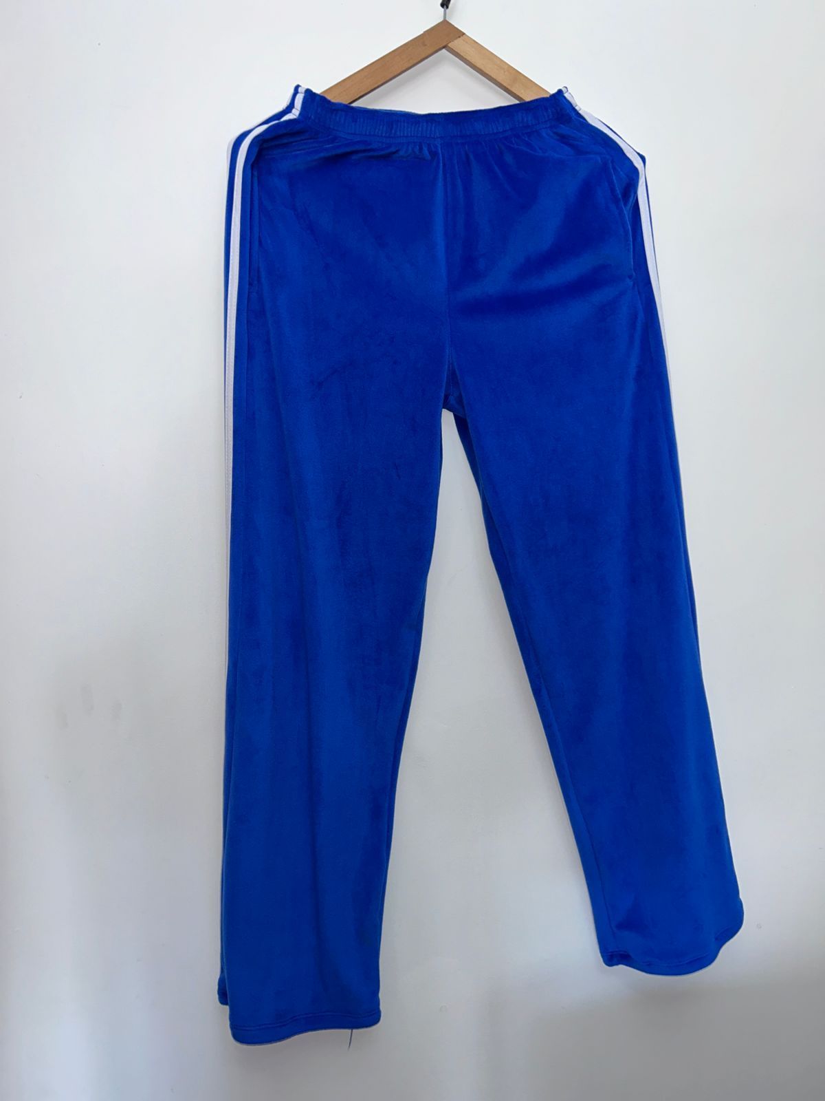 Un par de pantalones azules colgados en una percha de madera.