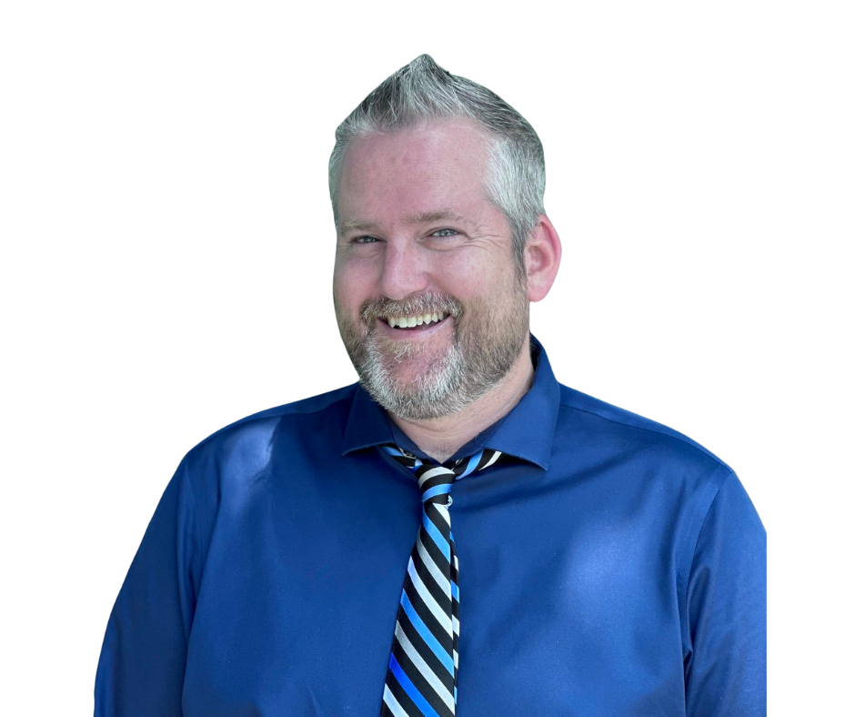 Man with graying hair and beard smiles, wearing a blue shirt and striped tie.