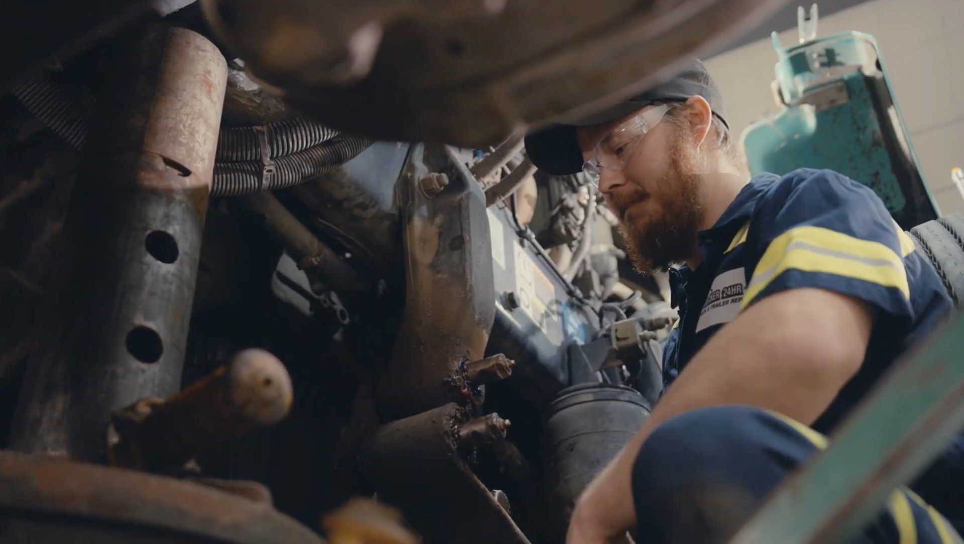 Rear view of a white semi-truck in a vehicle repair shop.