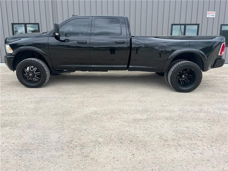 Black Ram pickup truck parked on gravel.