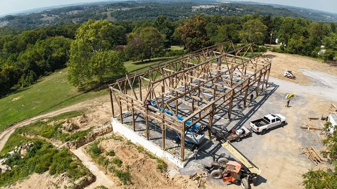 An aerial view of a building under construction in a field.