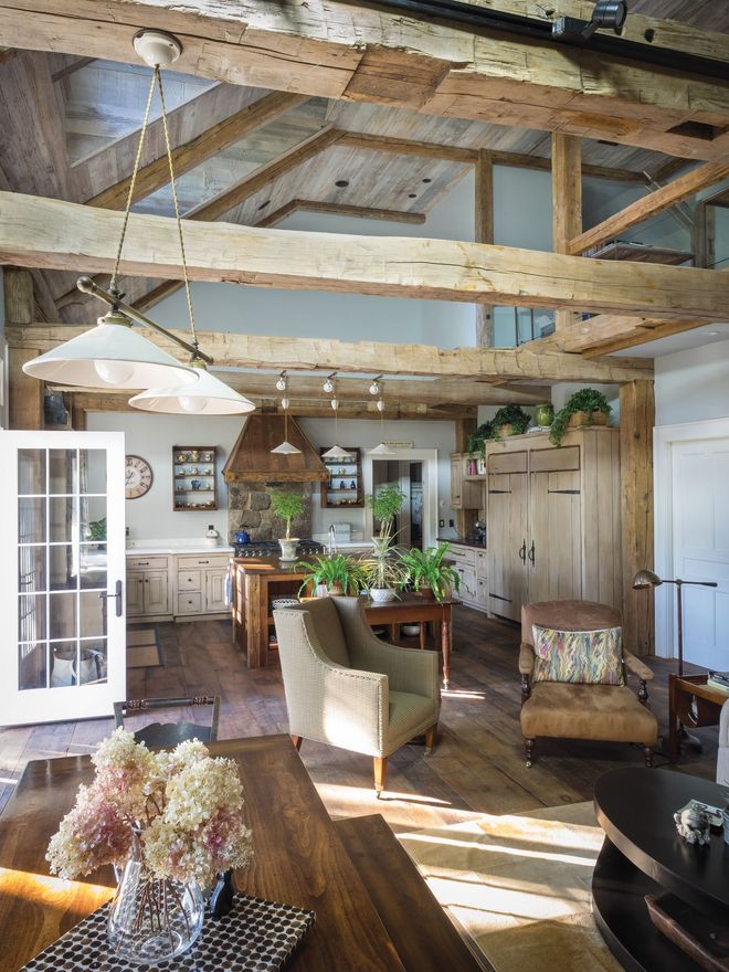 The inside of a barn with wooden beams and a metal roof.