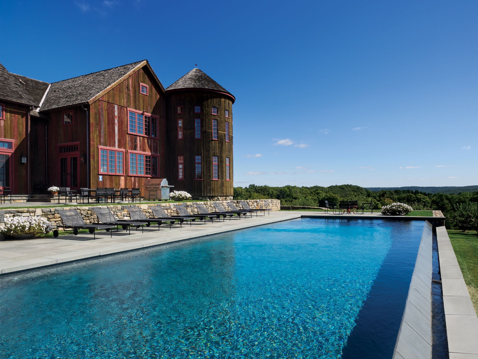 A man is standing next to a pile of wood in a workshop.
