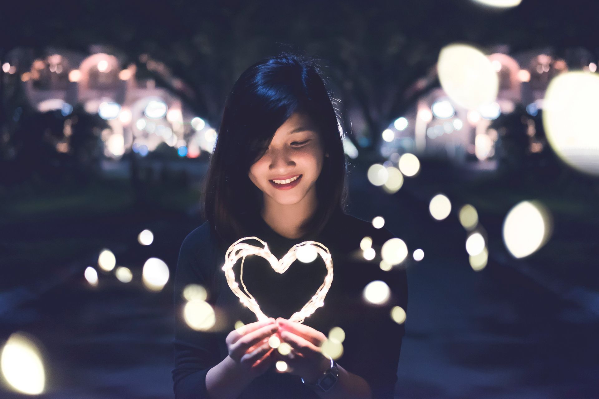 A smiling cute girl holding a heart of light for Denture Doctor Blogs