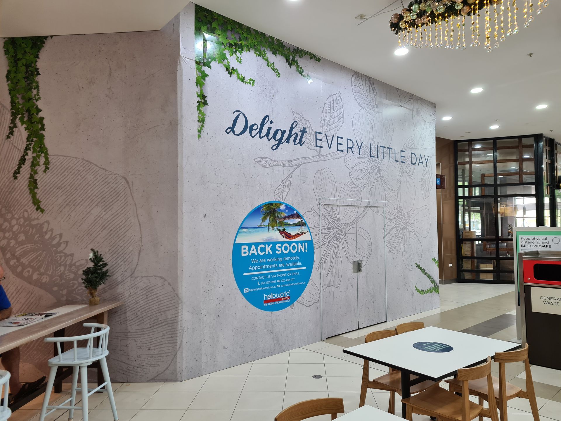 A restaurant with tables and chairs and a sign on the wall that says `` delight everyday ''-Professional Signwriter in the Illawarra