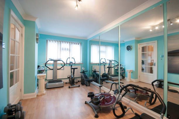 A gym with a lot of mirrors and exercise equipment