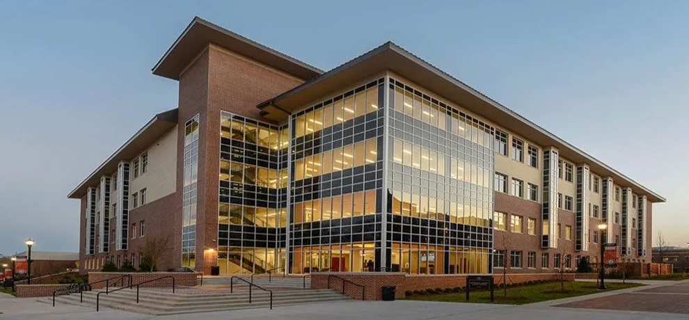 A large building with a lot of windows is lit up at night.