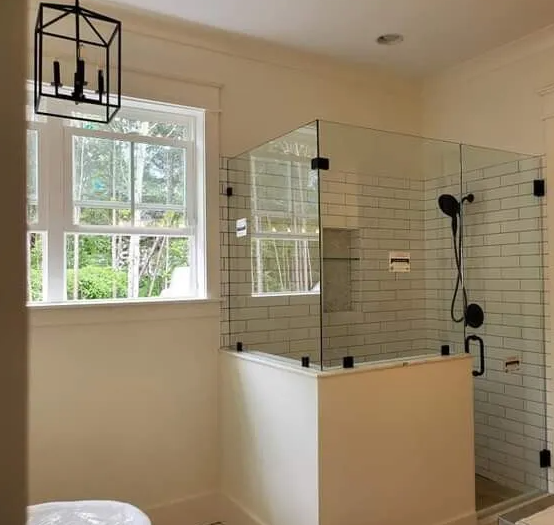 A bathroom with a walk in shower and a window.