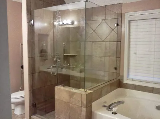 A bathroom with a tub , toilet , shower and window.