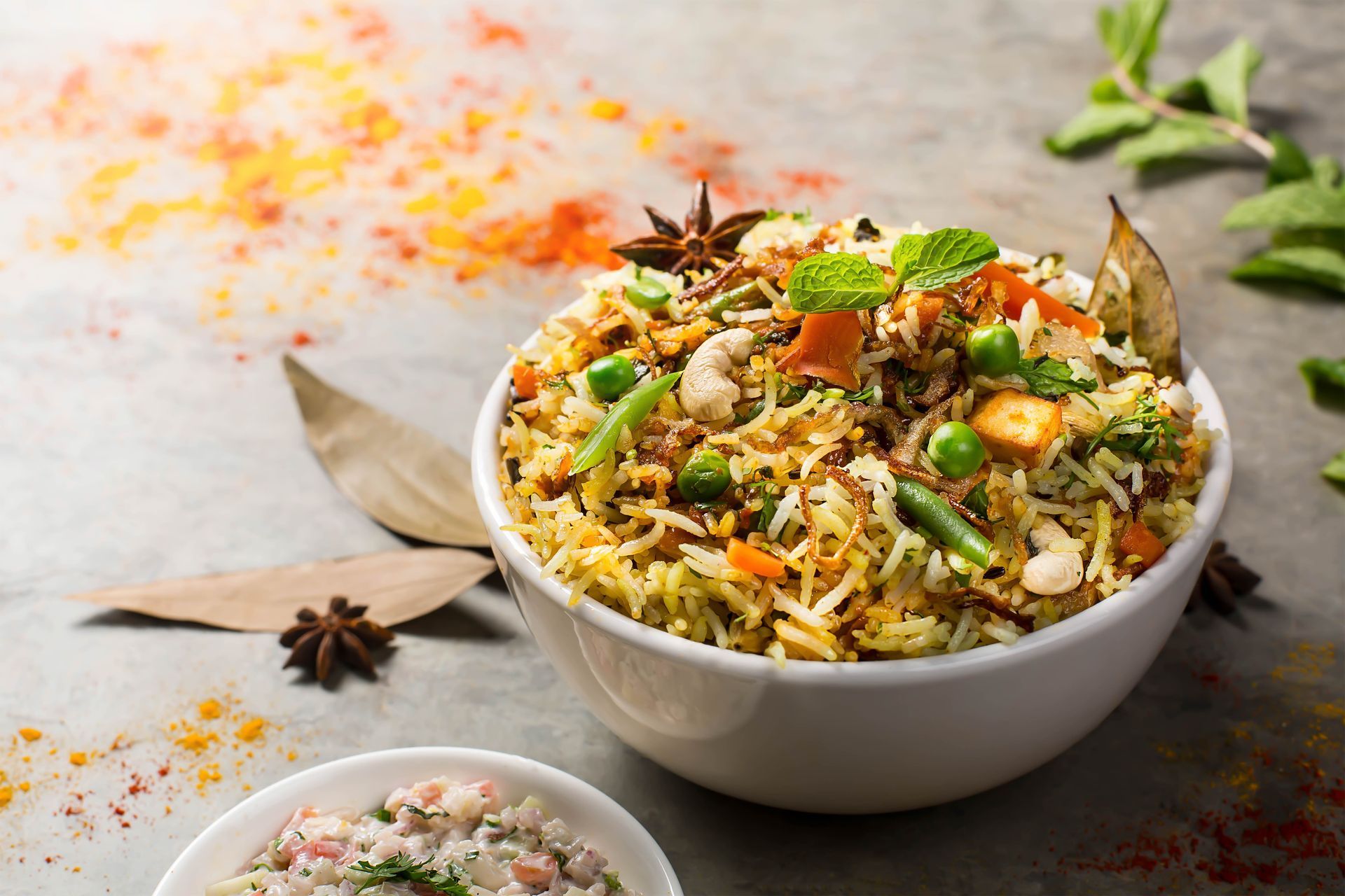 Bowl of vegetable biryani garnished with mint and spices.