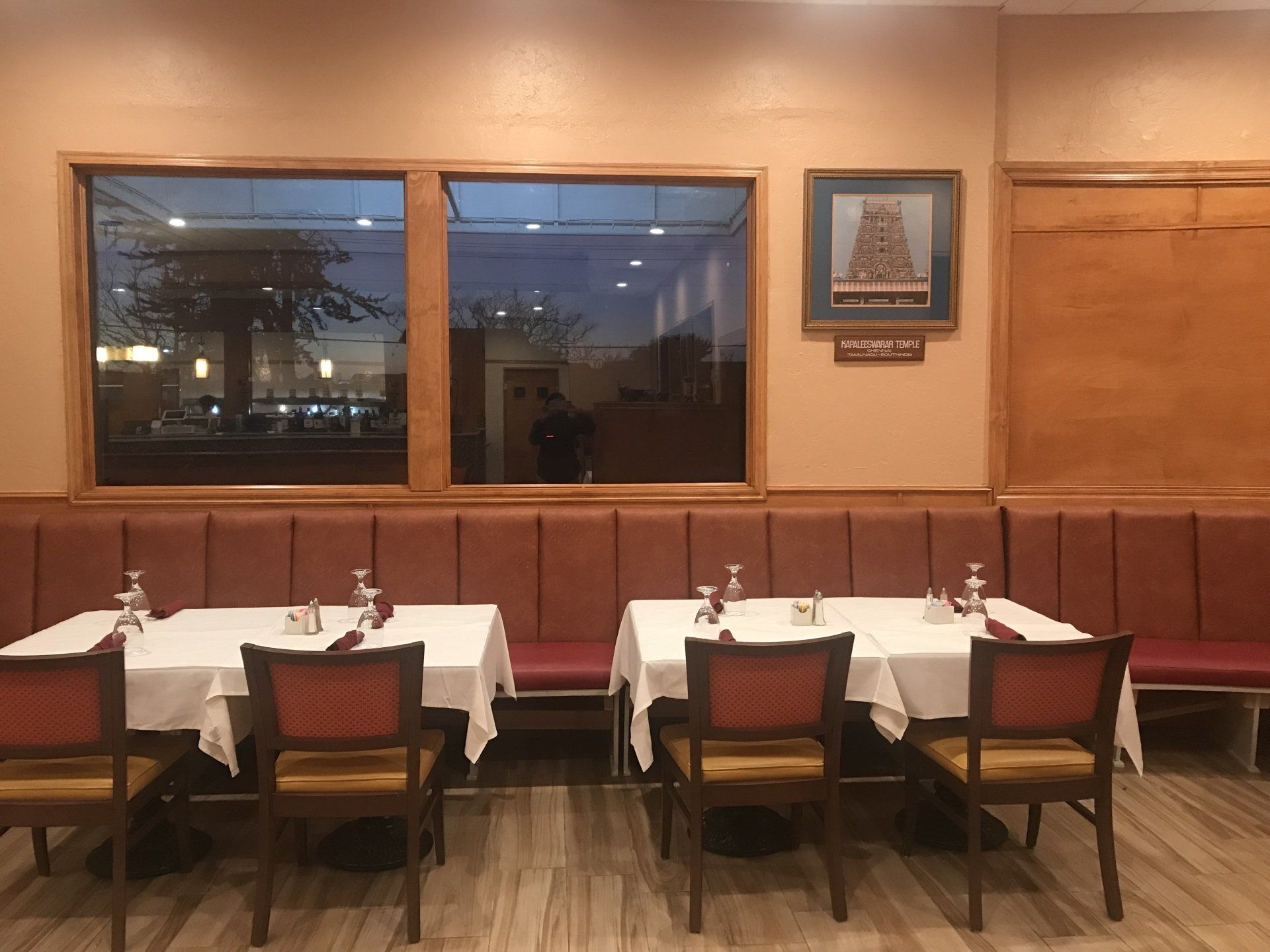 A restaurant with tables and chairs and a large window.