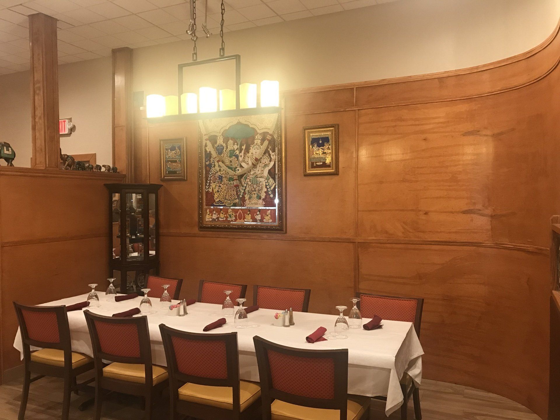 A long table and chairs in a restaurant with wooden walls.