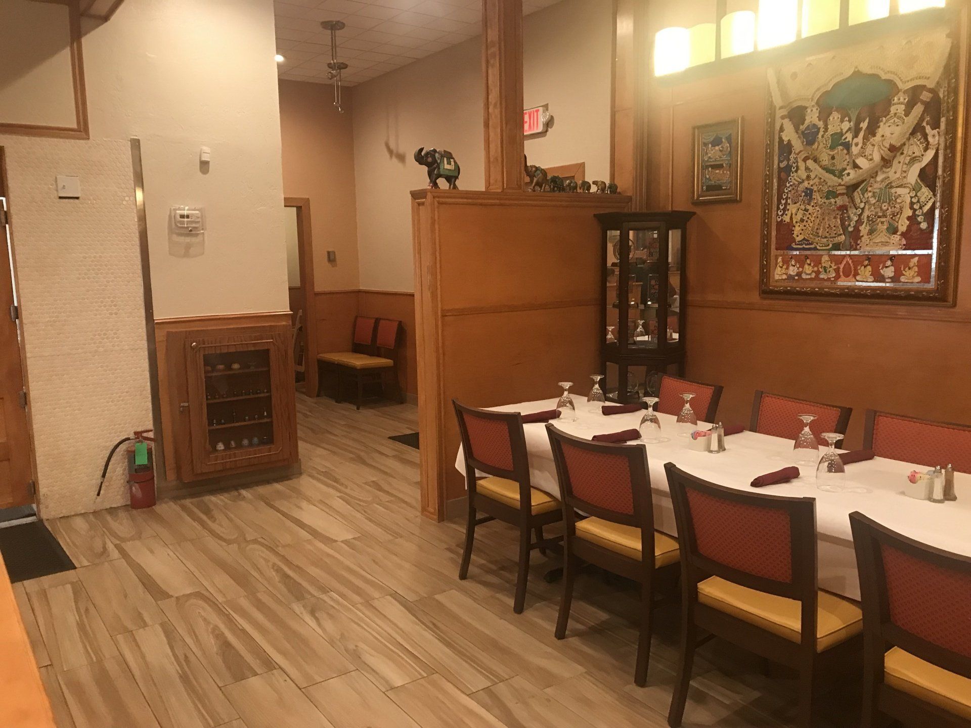 A dining room with tables and chairs and a fire extinguisher.