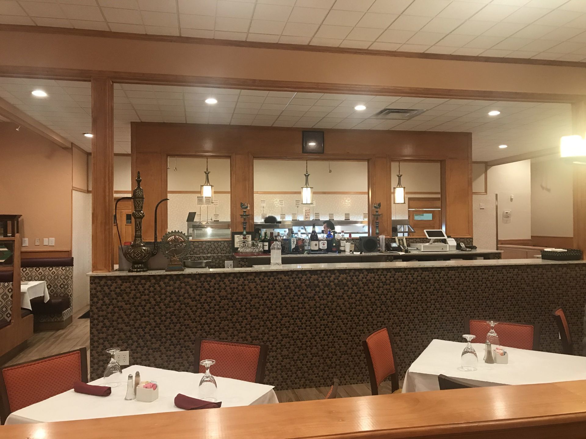 A restaurant with tables and chairs and a counter
