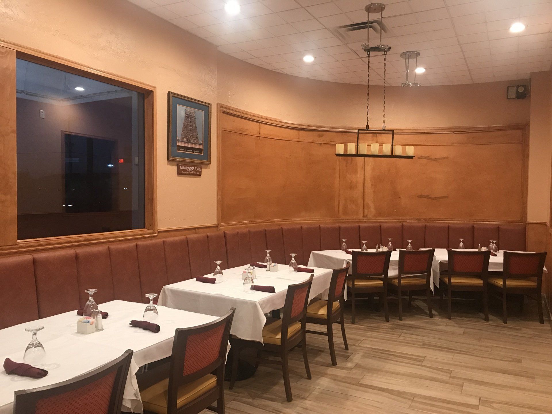 A restaurant with tables and chairs and a large window.