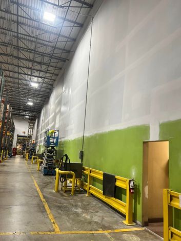 A man is painting the ceiling of a garage.