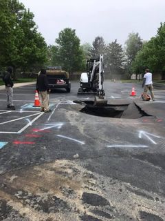 An empty parking lot with trees in the background